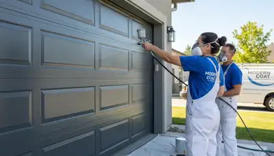 Professional painter refinishing a garage door in Kansas City, KS for lasting curb appeal